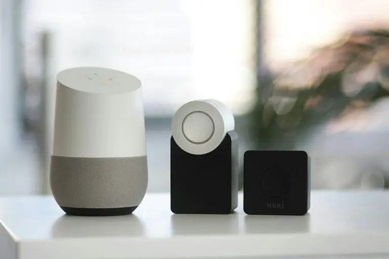 White and gray Google smart speaker and wo black speakers